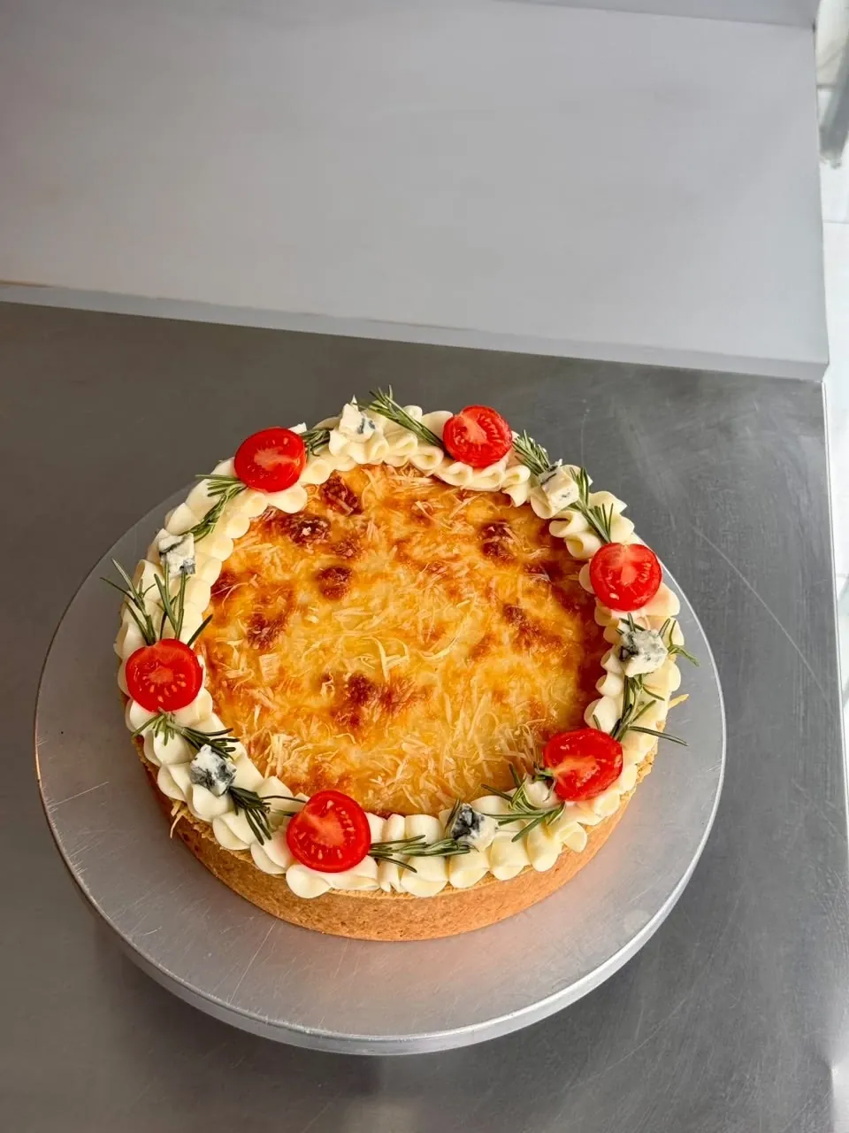 Quiche grande decorada da Chef Geicy com borda de creme, tomate cereja, alecrim e gorgonzola